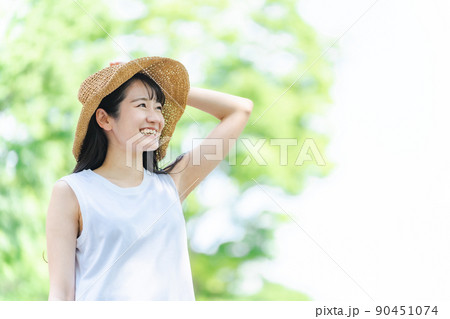 夏の旅行・レジャーに来た女性（新緑・笑顔） 90451074
