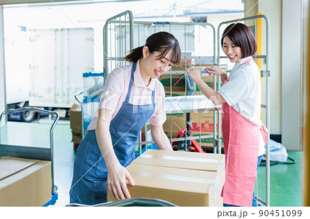 倉庫で明るく働く女性スタッフ 倉庫で明るく働く女性スタッフ 90451099