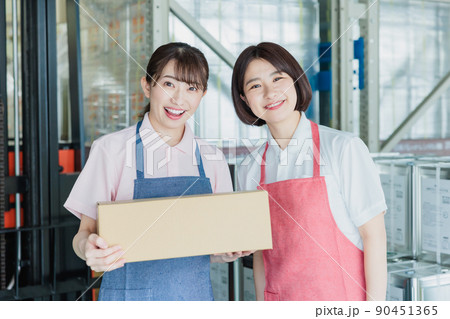 倉庫で明るく働く女性スタッフ 90451365