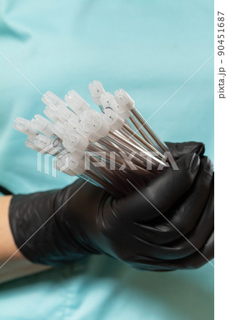 Dentist's hand in glove with saliva ejectors. Dentist's hand in glove with saliva ejectors. 90451687