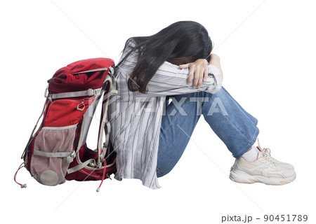 Asian woman sitting with her a backpack with tired expression 90451789