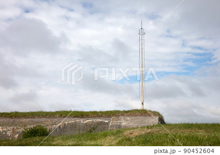 Old communication or radar tower on top of a ww2 bunker Old communication or radar tower on top of a ww2 bunker 90452604