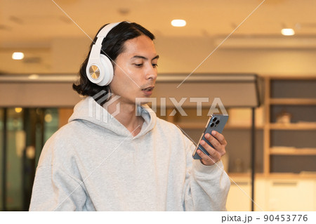 スマホの音楽を聴くヘッドフォンの男性 スマホの音楽を聴くヘッドフォンの男性 90453776