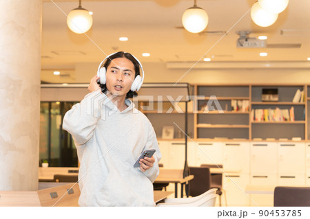 スマホの音楽を聴くヘッドフォンの男性 スマホの音楽を聴くヘッドフォンの男性 90453785
