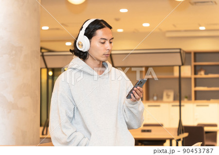 スマホの音楽を聴くヘッドフォンの男性 スマホの音楽を聴くヘッドフォンの男性 90453787