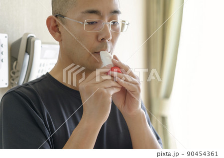 喘息の吸入薬を使う男性 90454361
