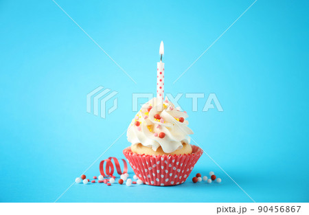 Delicious birthday cupcake with candle on light blue background 90456867