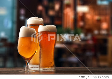 Three different glasses of beer on counter in pub. Three different glasses of beer on counter in pub. 90457289