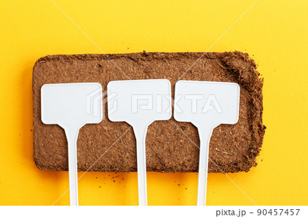 soil texture close up. mock up. coconut briquette with writing boards on a orange background. soil texture close up. mock up. coconut briquette with writing boards on a orange background. 90457457