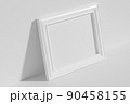 Horizontal rectangular photo frame on floor leaning at wall top diagonal view 90458155