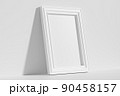 Rectangular photo frame on floor leaning at wall diagonal view 90458157
