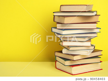 Stack of hardcover books on yellow background. Space for text Stack of hardcover books on yellow background. Space for text 90458403