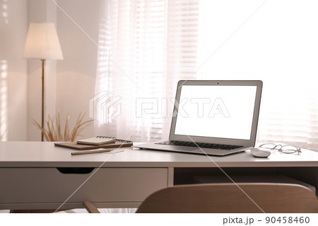 Laptop on desk near window in office. Comfortable workplace 90458460