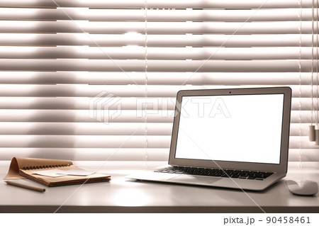 Laptop on desk near window in office. Comfortable workplace 90458461