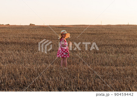 Child girl in straw hat dress in wheat field. Smiling kid in sunglasses sunset countryside. Cottagecore style aesthetic. Child girl in straw hat dress in wheat field. Smiling kid in sunglasses sunset countryside. Cottagecore style aesthetic. 90459442