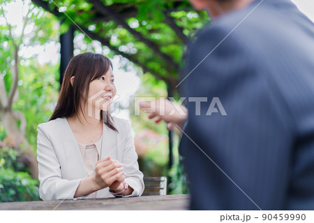 屋外で意見交換をするビジネスウーマン 90459990