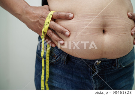 Asian woman show fat belly big size overweight and obesity at office. 90461328