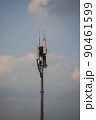 Birds nest on a cell tower with clouds 90461599