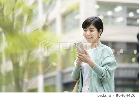 スマートフォンの画面を見る若い女性 スマートフォンの画面を見る若い女性 90464420