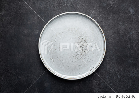 Empty ceramic plate isolated on black stone background 90465246