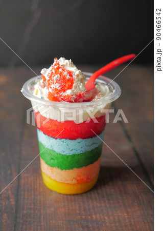 rainbow color cake in a plastic container on table  90466542