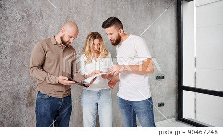 Man and woman looking at catalogue while choosing interior design for new apartment with professional designer. Couple planning home renovation and redesigning with specialist. Man and woman looking at catalogue while choosing interior design for new apartment with professional designer. Couple planning home renovation and redesigning with specialist. 90467248