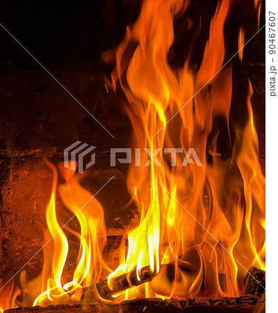 Flames of fire on a black background. Burning wood in the fireplace Flames of fire on a black background. Burning wood in the fireplace 90467607