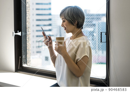 オフィスでスマホを操作するシニアビジネスウーマン 90468583