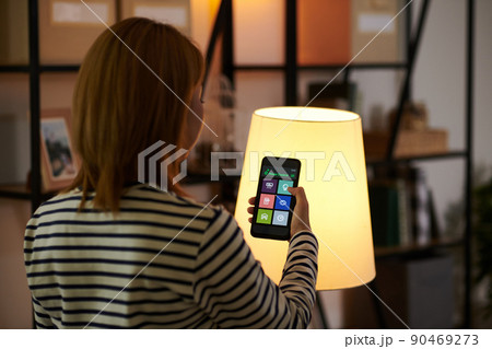 Woman Dimming Lights in Room Woman Dimming Lights in Room 90469273