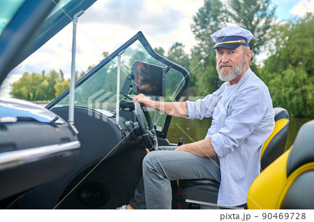 A man in a captains cap getting the boat ready A man in a captains cap getting the boat ready 90469728