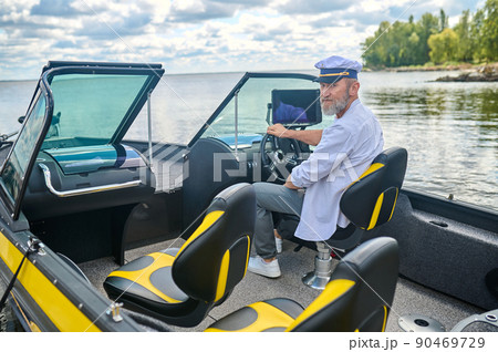 A man in a captains cap getting the boat ready 90469729