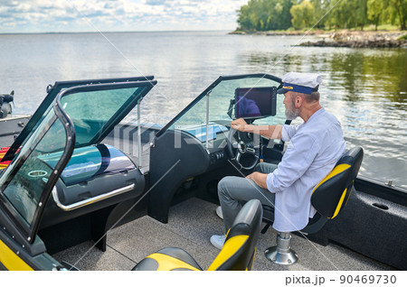 A man in a captains cap getting the boat ready 90469730