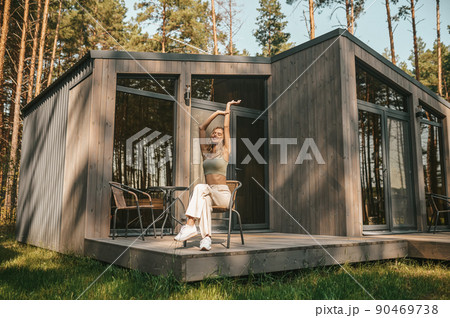 Joyful young blonde woman seated on the veranda 90469738