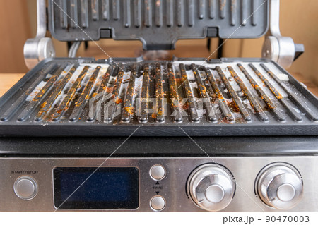 Dirty electric grill. Fat spots on a frying pan. Drops of fat. 90470003