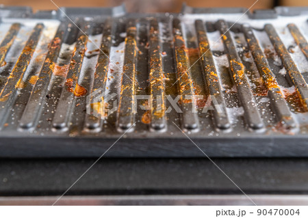 Dirty electric grill. Fat spots on a frying pan. Drops of fat. 90470004