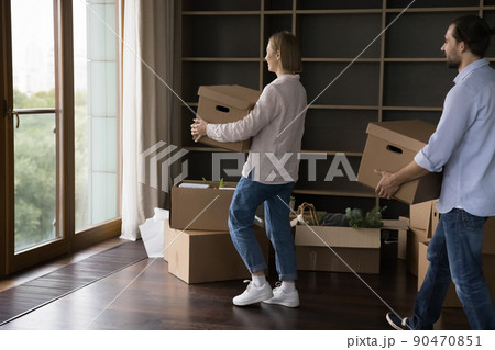 Couple carrying cardboard boxes with stuff to first own house Couple carrying cardboard boxes with stuff to first own house 90470851