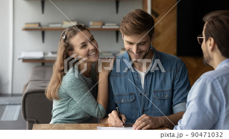 Happy young married couple buying house, signing property purchase contract Happy young married couple buying house, signing property purchase contract 90471032