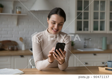 Happy young adult millennial girl chatting on mobile phone 90471137