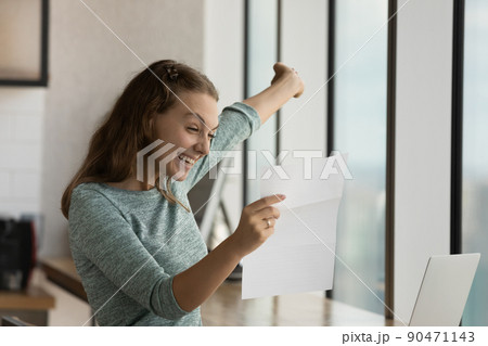 Happy excited student girl reading paper letter with good news, Happy excited student girl reading paper letter with good news, 90471143