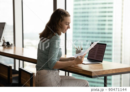 Serious student girl working on research paper, reviewing paper letter Serious student girl working on research paper, reviewing paper letter 90471144