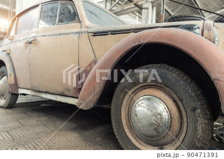 Side rusty abandoned forgotten antique oldtimer old car and motorcycles at junkyard factory storage warehouse indoors. Classic vintage retro vehicles detail garage workshop restore renovation station 90471391
