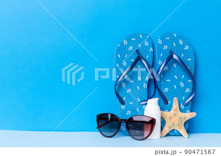 Beach accessories. Flip flops and starfish on colored background. Mock up with copy space Beach accessories. Flip flops and starfish on colored background. Mock up with copy space 90471567