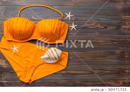 Woman swimwear and beach accessories flat lay top view on colored background Summer travel concept. bikini swimsuit, straw hat and seasheels. Copy space Top view Woman swimwear and beach accessories flat lay top view on colored background Summer travel concept. bikini swimsuit, straw hat and seasheels. Copy space Top view 90471735