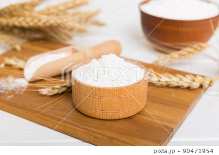Flat lay of Wheat flour in wooden bowl with wheat spikelets on colored background. world wheat crisis 90471954