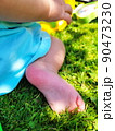 cute little baby feet on summer green grass. Pink, delicate skin of the heel, against the background of a bicycle. Summer, day, bright sun. 4k video 90473230