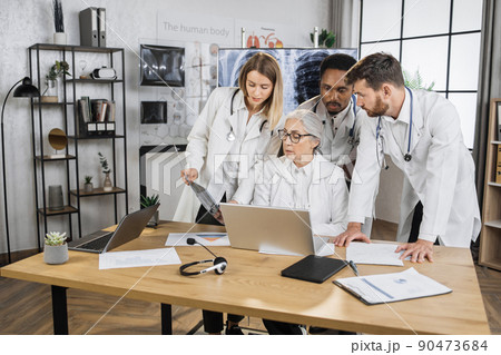 Interns having meeting with senior doctor in hospital office 90473684