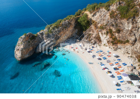 Aerial view of blue sea, rock, sandy beach with umbrellas 90474038