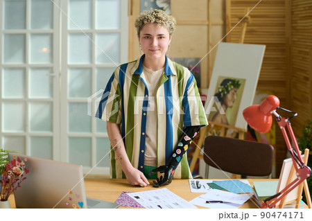 Young female with myoelectric arm decorated with small handmade stickers 90474171