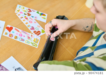 Above view of young female putting handmade stickers on her myoelectric arm 90474181