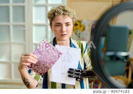 Young creative female fashion designer showing drawing to online audience 90474183